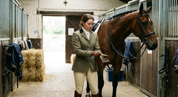 Reiterin bereitet sich mit Handschuhen aufs Reiten vor